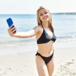 Una donna in bikini si fa un selfie sulle spiagge di Procida.