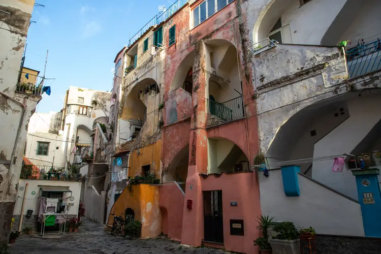 Una strada stretta con edifici casalinghi colorati e balconi.