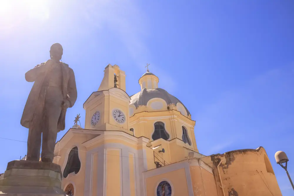 Semmarezio a Procida, statua di un uomo in piedi davanti ad una chiesa.