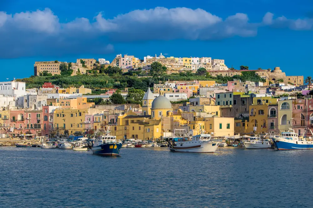 Procida è una città sulla costa con le barche ormeggiate nel porto.