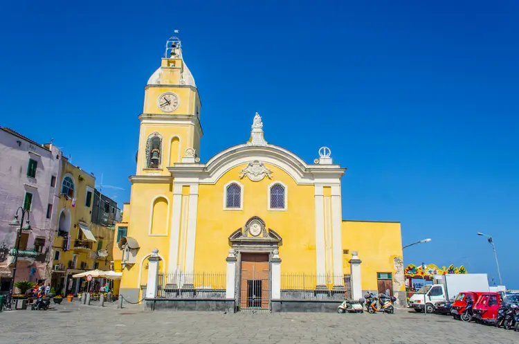 chiesa di santa maria della pieta procida Una chiesa gialla con davanti la torre dell'orologio, situata a Procida.
